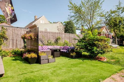 a backyard with a garden with flowers and a fence at Witch City Retreat with Tiki Bar in Downtown Salem in Salem