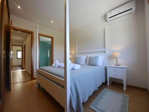 ein Schlafzimmer mit einem großen Bett und einem Spiegel in der Unterkunft Charming Caminha Villa 4 Bedrooms Villa Caminha View Private Pool in Caminha
