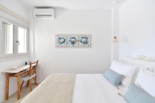 a white bedroom with a bed and a table at Luxury Paros Villa Villa Aethra Beautiful & Serene Glisidia in Kampos Paros