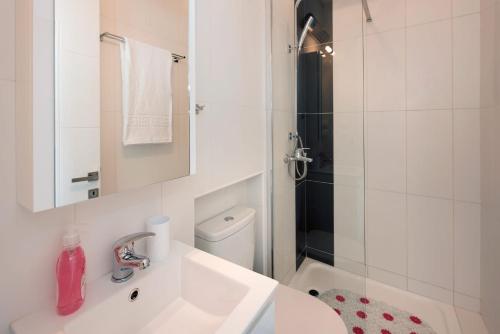 un bagno bianco con lavandino e doccia di Astounding Corfu Villa 2 Bedrooms Villa Clara Wonderful Sea & Mountain Views Pirgi a Pyrgi