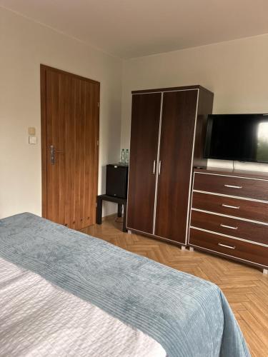 a bedroom with a bed and a flat screen tv at Świat Jezior in Mikołajki