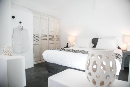 a white bedroom with a bed and a vase at Luxury Santorini Villa Ocean Breeze Villa 2 Bedrooms Sea & Caldera View Jacuzzi & Plunge Oia in Thólos