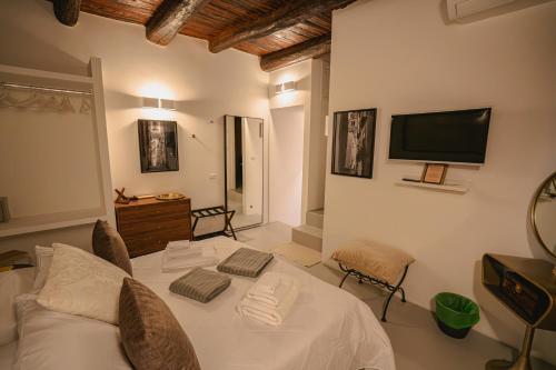 a bedroom with a bed and a tv on the wall at Lùbea Apartment - Vinto House Collections in Salerno