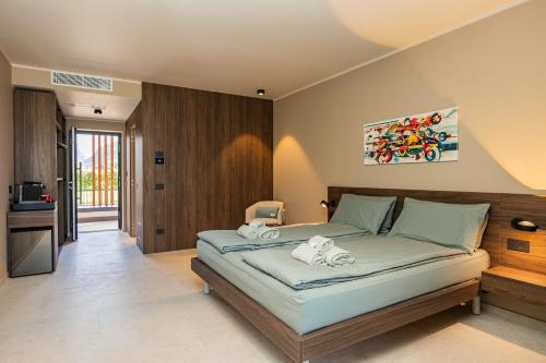 a bedroom with a large bed with towels on it at Vinea Rural Resort - Adults only in Arco