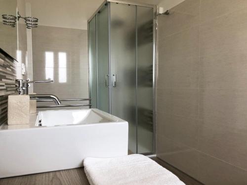 a bathroom with a shower with a tub and a sink at Accòmodati - Camere e Appartamenti in Marina di Gioiosa Ionica