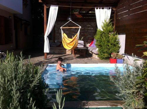 Ein Junge im Pool im Garten in der Unterkunft Great Pelion Villa Villa Dioni 2 Bedrooms Aghios Georgios in Pilion