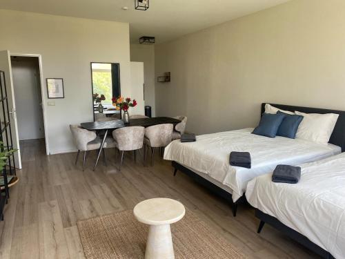 a bedroom with two beds and a table and a dining room at Cozy and best location! 6 person in Rotterdam