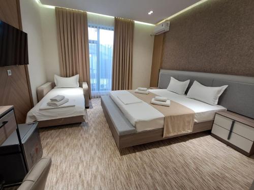 a hotel room with two beds and a television at North Star Hotel in Yakkasaray