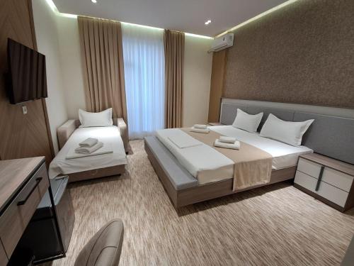 a hotel room with two beds and a television at North Star Hotel in Yakkasaray