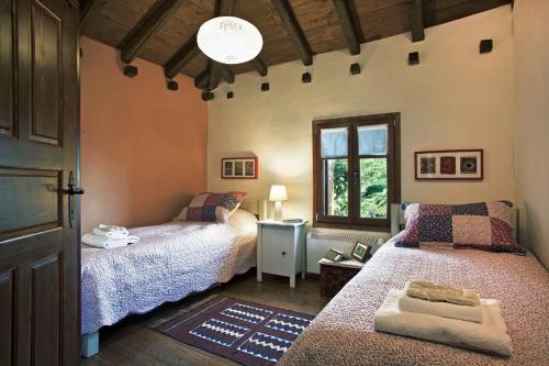 ein Schlafzimmer mit zwei Betten und einem Fenster in der Unterkunft Great Pelion Villa Villa Dioni 2 Bedrooms Aghios Georgios in Pilion