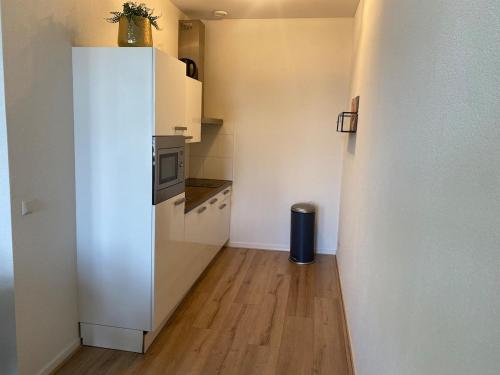 a kitchen with a white refrigerator and a wooden floor at Cozy and best location! 6 person in Rotterdam