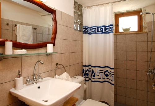 a bathroom with a sink and a toilet and a mirror at Extravagant Zante Villa Villa Purple Great Sea Views 3 Bedrooms Agios Nikolaos in Koríthion