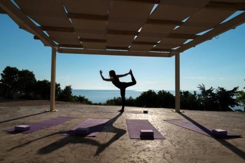 a woman standing in a yoga pose in front of the ocean at Extravagant Zante Villa Villa Crystal Great Sea Views 3 Bedrooms Agios Nikolaos in Koríthion