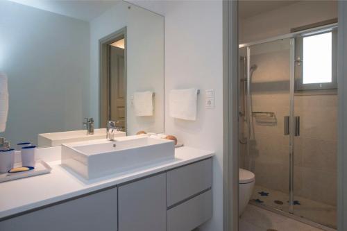 un bagno bianco con lavandino e doccia di Platinum Paros Villa Ocyrhoe Iii Villa 4 Bedrooms Private Pool & Fantastic Sea Views Parikia a Paroikia