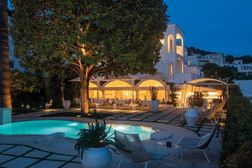 a resort with a pool and chairs and a building at Pazziella Garden & Suites in Capri