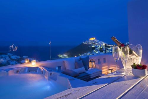 a table with a couch and wine glasses on it at Elegant Astypalaia Villa Villa Ble Air Conditioning Hot Tub in Astypalaia Town