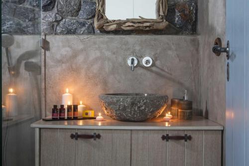 a bathroom with a bowl sink and candles on a counter at Elegant Astypalaia Villa Villa Ble Air Conditioning Hot Tub in Astypalaia Town