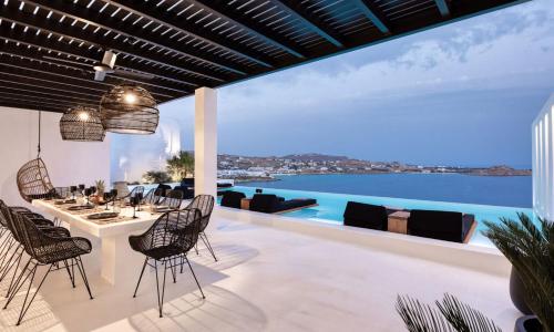 ein Esszimmer im Freien mit Meerblick in der Unterkunft Dazzling Mykonos Villa Villa Lvellie 6 Bedrooms Unique Aegean Sea Views in Psarrou