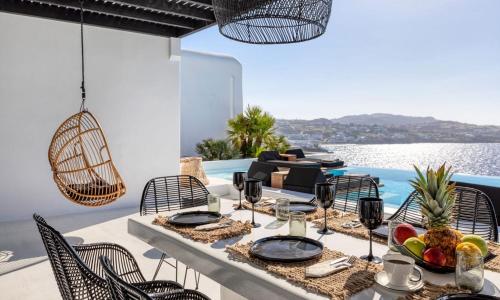 ein Esstisch mit einer Obstschale auf einer Terrasse in der Unterkunft Dazzling Mykonos Villa Villa Lvellie 6 Bedrooms Unique Aegean Sea Views in Psarrou