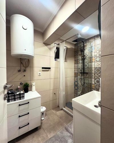 a bathroom with a shower and a toilet and a sink at Mira Apartmani in Mostar