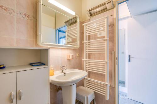 une salle de bain avec un lavabo et un miroir dans l'établissement Sur les hauteurs du Fidji, à La Grande Motte