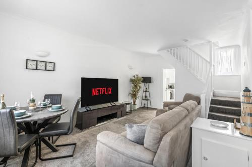 a living room with a couch and a tv at Little Wiston- With free parking in Worthing