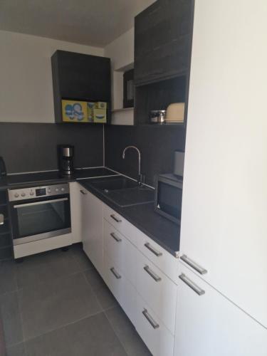 a kitchen with white cabinets and a sink at Ferienwohnung mit Whirpool und Fasssauna - Medebach in Medebach