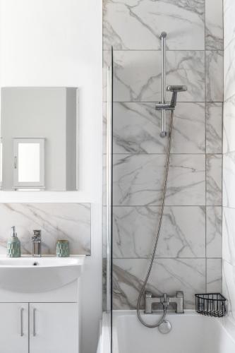a white bathroom with a shower and a sink at Little Wiston- With free parking in Worthing