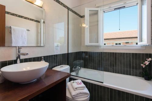 a bathroom with a sink and a tub and a window at Luxurious Agios Georgios Villa Private Pool Villa Spyridoula Beach Paradise in Agios Georgios