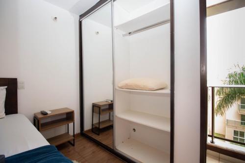 a room with a bed and a glass wall at OZPED Flats Particulares Edifício Life Resort in Brasilia