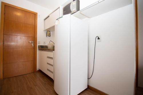 a white refrigerator in a kitchen with a door at OZPED Flats Particulares Edifício Life Resort in Brasilia