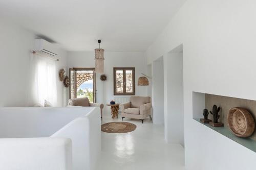 a living room with white walls and white furniture at Executive Paros Villa Villa Aiolos Private Pool & Jacuzzi Villa Kostos Damouli in Kampos Paros