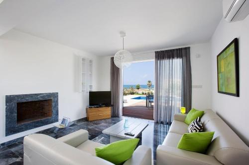 a living room with a couch and a fireplace at Luxury Cyprus Villa Turquoise Villa Private Pool Sea View Paphos in Paphos