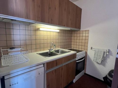 une petite cuisine avec un évier et une cuisinière dans l'établissement Appartement T2 Climatisé avec Piscine, Terrasse et Accès Direct Plage, 4 Couchages – Le Barcarès - FR-1-81-510, au Barcarès