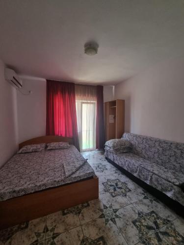 a bedroom with two beds and a window at Casa Natalia in Eforie Nord