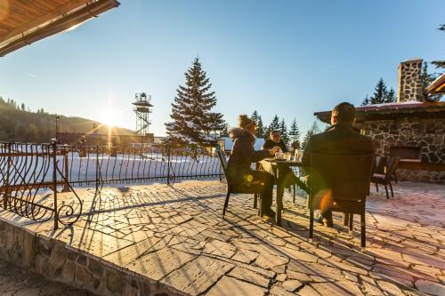 a group of people sitting at a table on a patio at Hotel Sachticka in Banská Bystrica