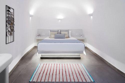 a white bedroom with a bed and a red rug at Finikia -Foinikia - Luxury Cave - A Wonderful 2 Bedroom Villa - Hot Tub in Foinikiá