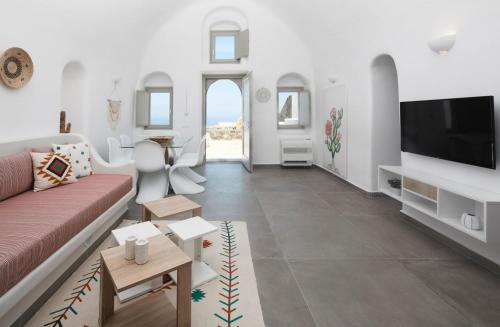 a living room with a couch and a flat screen tv at Finikia -Foinikia - Luxury Cave - A Wonderful 2 Bedroom Villa - Hot Tub in Foinikiá