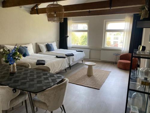 a bedroom with two beds and a table and chairs at Cozy and centrally located - 6 persons apartment in Rotterdam