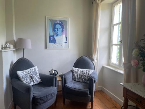 a living room with two chairs and a picture on the wall at La Cerisaie - Chambres d'hôtes & gites in Riols