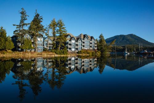 a house on the water with its reflection in the water at Waters Edge Shoreside Suites in Ucluelet