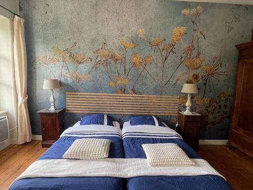 two beds in a bedroom with a floral wallpaper at La Cerisaie - Chambres d'hôtes & gites in Riols