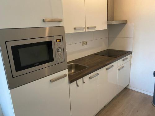 a kitchen with a microwave and a sink at Cozy and centrally located - 6 persons apartment in Rotterdam