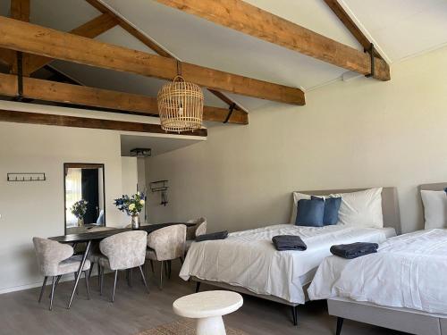 a bedroom with two beds and a table and chairs at Cozy and centrally located - 6 persons apartment in Rotterdam