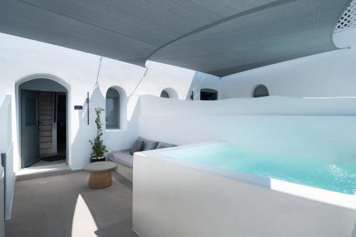 a white house with a swimming pool at Magnificent Santorini Suite Luxury Suite With Sea View And Hot Tub Oia in Oia