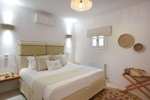 ein weißes Schlafzimmer mit einem großen Bett mit weißen Kissen in der Unterkunft Executive Paros Villa 4 Bedrooms Villa Island Spirit Amazing Sea Views in Kampos Paros