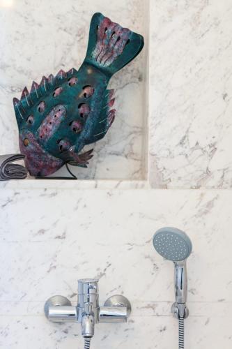 a statue of a fish on a wall next to a sink at Extraordinary Rethymno Villa Villa Hantengu 3 Bedrooms Beach Front Private Outdoor Swimming Pool And Hot Tub Pigianos Kampos in Pigianos Kampos