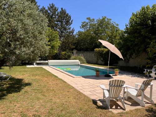 une piscine avec deux chaises et un parasol dans l'établissement La Fanette de Lure, à Pierrerue