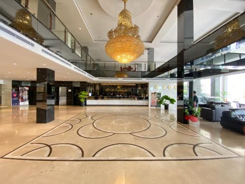 a lobby with a large rug in the middle of a building at Alltrue Sydney Hotel Batam Center in Batam Center