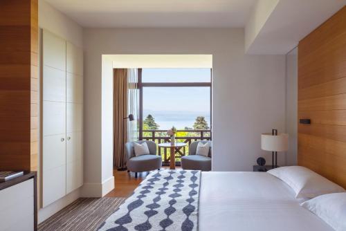 a bedroom with a bed and a view of the ocean at Hôtel Ermitage in Évian-les-Bains